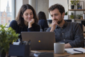 Two colleagues reacting differently to the same workplace message.